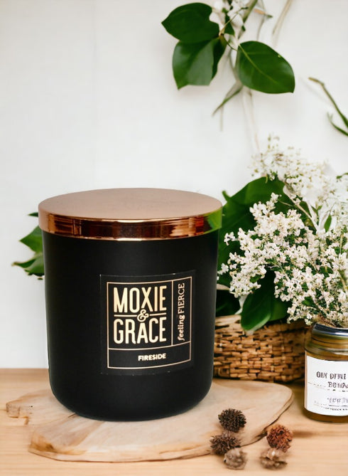 Fireside 12oz Candle in Black by Moxie & Grace — a warm, smoky blend of cedarwood, sandalwood, birch, and smoked amber