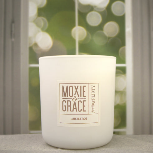 Mistletoe 12oz Candle in White by Moxie & Grace — a festive blend of pine, peppermint, eucalyptus, and fresh winter greens