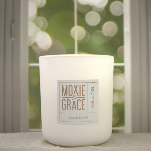 Solar Sands 12oz Candle in White by Moxie & Grace — a warm, sun-drenched blend of sand, amber, musk, and golden citrus notes