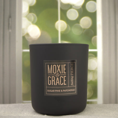 Sugar Pine & Patchouli 12oz Candle in Black by Moxie & Grace — an earthy, woodsy blend of pine, patchouli, cedar, and warm musk